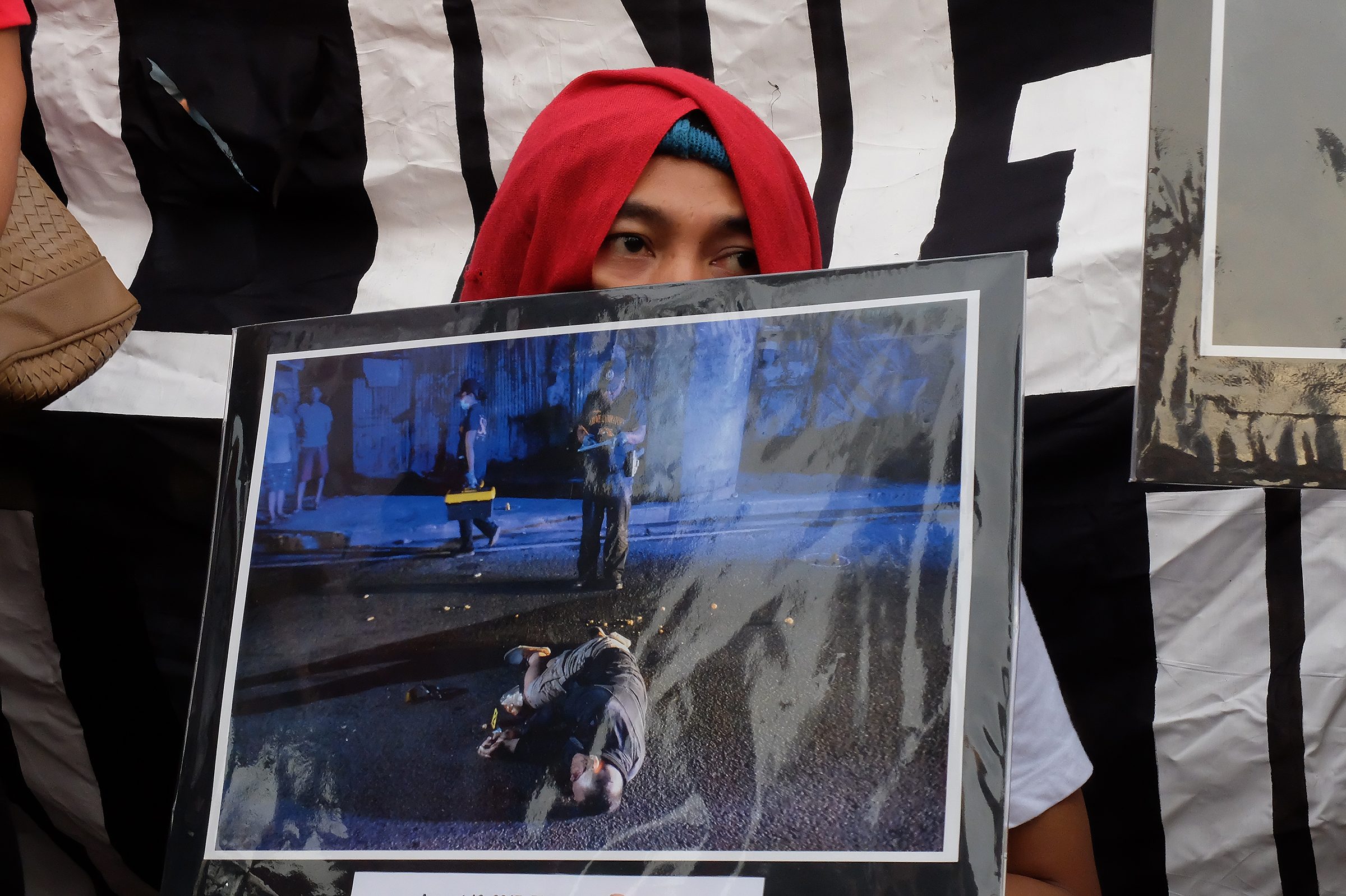JUSTICE. A woman holds up a photo of a relative – one among thousands killed in the government's fight against illegal drugs – during an indignation rally in Quezon City on August 18, 2017. Photo by Maria Tan/Rappler   