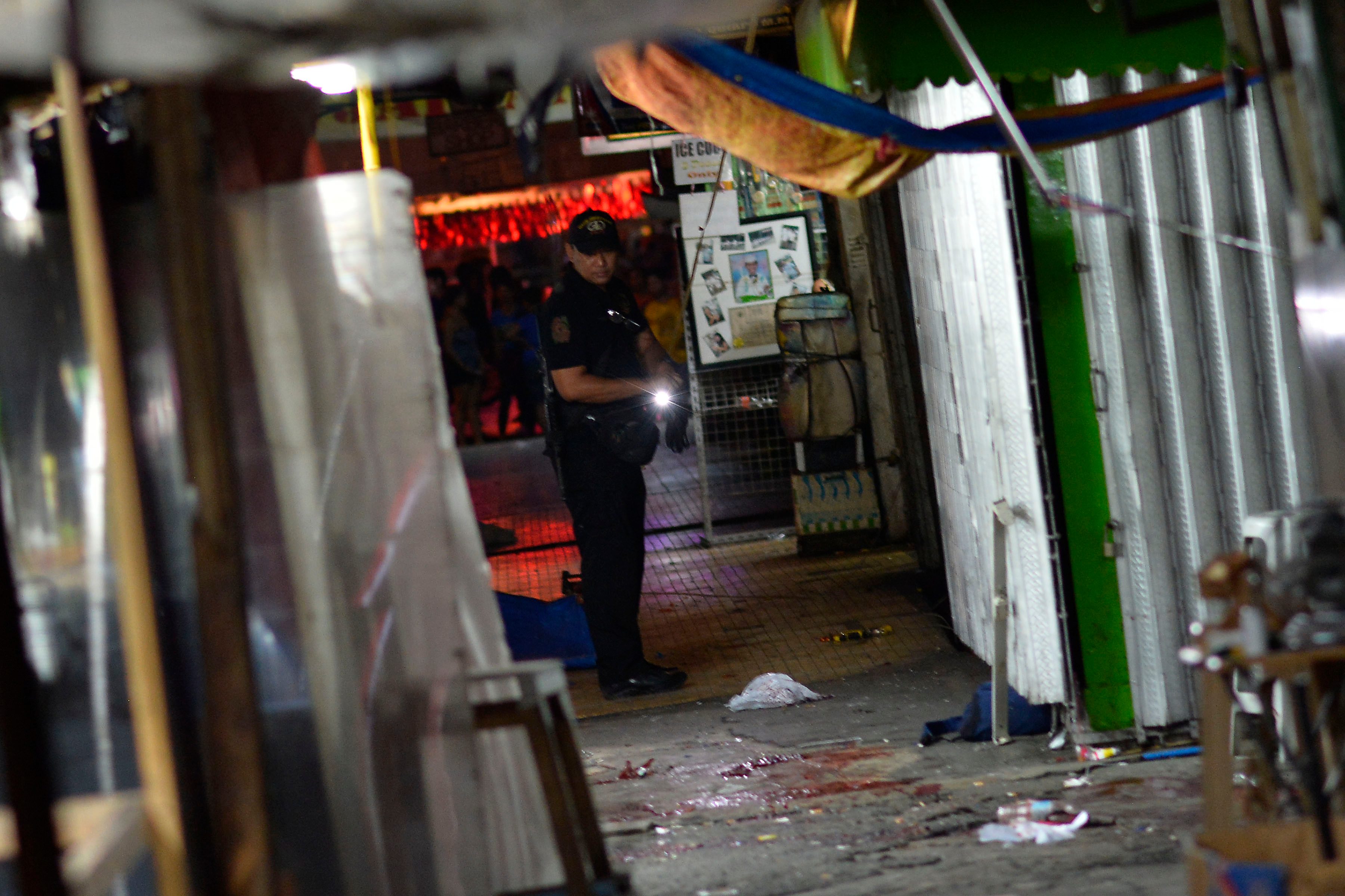 CRIME SCENE. Blood is on the floor as a policeman walks toward the scene of the explosion on April 28, 2017. Photo by Ezra Acayan. 