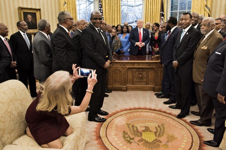 PHOTO OP. Counselor to the President Kellyanne Conway takes a photo as US President Donald Trump and leaders of historically black universities and colleges talk before a group photo in the Oval Office of the White House before a meeting with US Vice President Mike Pence February 27, 2017 in Washington, DC. Brendan Smialowski/AFP 
