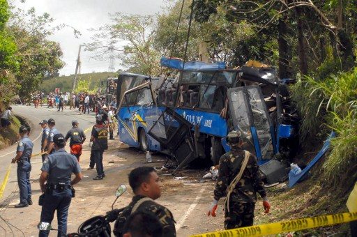 Police and soldiers stand guard next to a tourist bus which hit an electric post in Tanay town, Rizal province, east of Manila on February 20, 2017. Stringer/AFP 