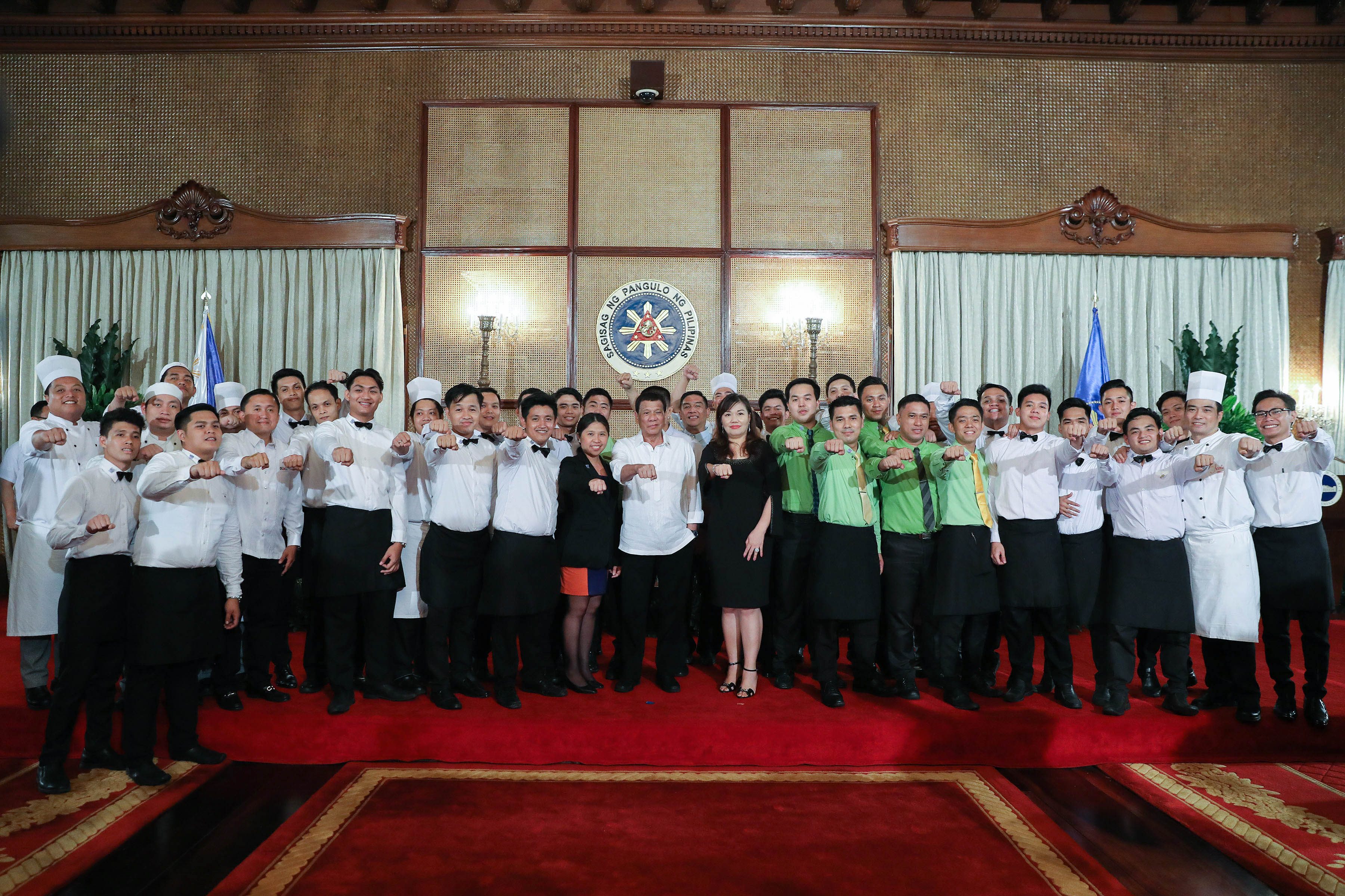 President Rodrigo Roa Duterte and his long-time partner Cielito "Honeylet" Avanceña flash the President's signature pose with the catering service personnel who served during a dinner he hosted at the Malacañan Palace on May 7, 2019. Photo by Valerie Escalera/Presidential Photo 