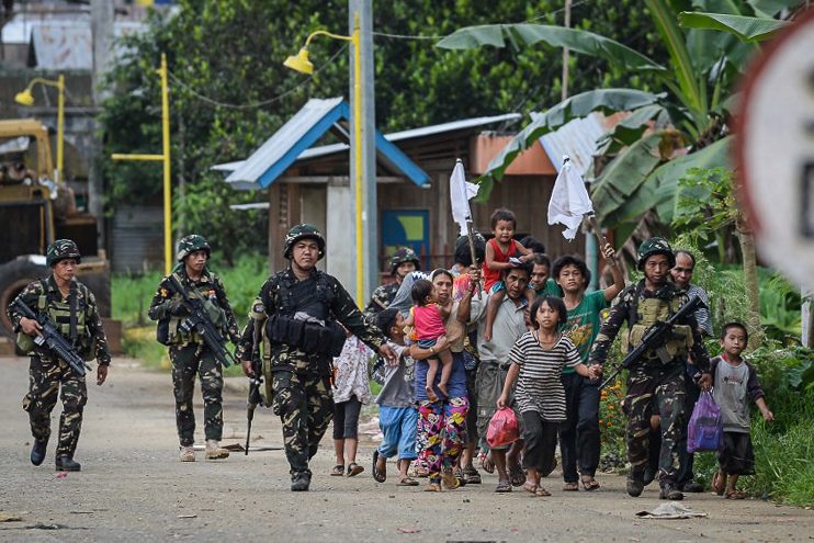 WAR AND LANGUAGE. In this file photo, soldiers escort rescued civilians at a village on the outskirts of Marawi on May 31, 2017. Photo by Ted Aljibe/AFP 