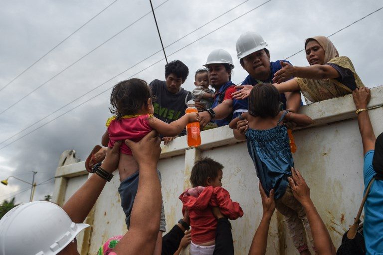 CHILDREN. Rescue workes load children onto a truck after government troops evacuated trapped residents from their homes in the outskirts of Marawi on May 31, 2017. Photo by Ted Aljibe/AFP 