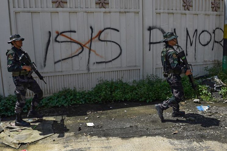 ISIS SCOURGE. Soldiers walk past Islamic State (ISIS) group graffiti in Marawi on on May 31, 2017. Photo by Ted Aljibe/Agence France-Presse 