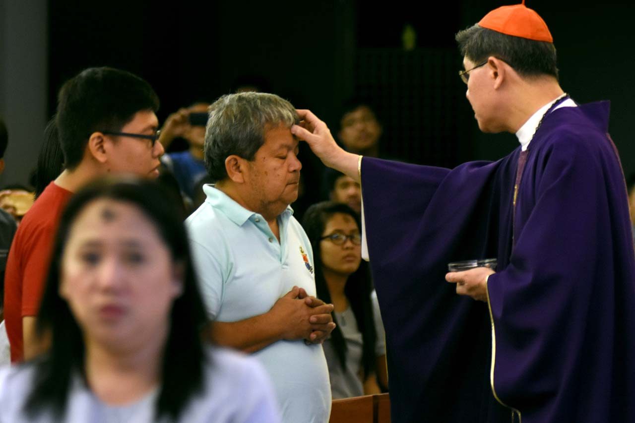 ASH WEDNESDAY. Manila Archbishop Luis Antonio Cardinal Tagle puts ashes on the foreheads of Catholics on March 1, 2017, as they mark Ash Wednesday, the start of the penitential season of Lent. Photo by Angie de Silva/Rappler   