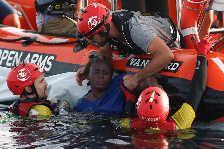 SEA MIGRANTS. Members of the Spanish NGO Proactiva Open Arms rescue a woman in the Mediterranean open sea about 85 miles off the Libyan coast on July 17, 2018. Photo by Pau Barrena/AFP   