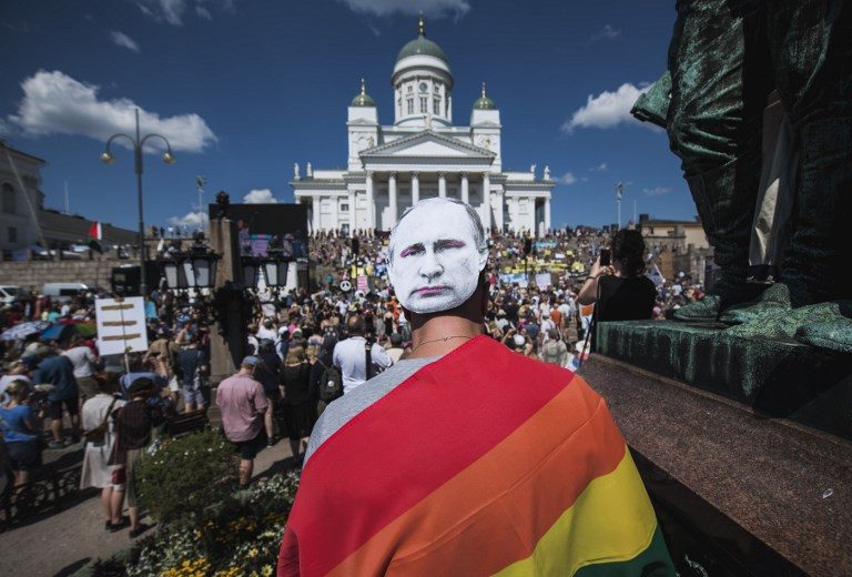 HELSINKI CALLING. A protester wears a mask bearing the portrait of Russian President Vladimir Putin as they gather on July 15, 2018, ahead of the arrival of US President for a summit with his Russian counterpart in the Finnish capital Helsinki. Photo by Jonathan Nackstrand/AFP   