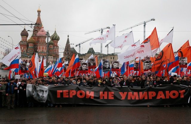 IN THE SHADOW OF ST. BASIL'S. People carry a poster with portrait of murdered Russian opposition veteran leader Boris Nemtsov and words saying 'The heroes do not die. These bullets - in each of us' as they march in his memory in central Moscow, Russia, 01 March 2015. Sergei Ilnitsky/EPA 