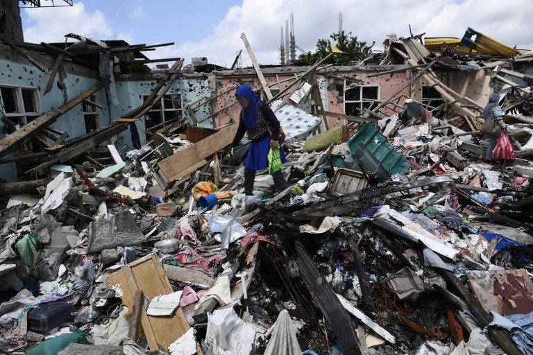 WHAT'S LEFT. A resident looks through the rubble of her destroyed house, as she tries to salvage belongings during a visit to the main battle area in Marawi City on April 1, 2018, their first visit back. Photo by Ted Aljibe/AFP 