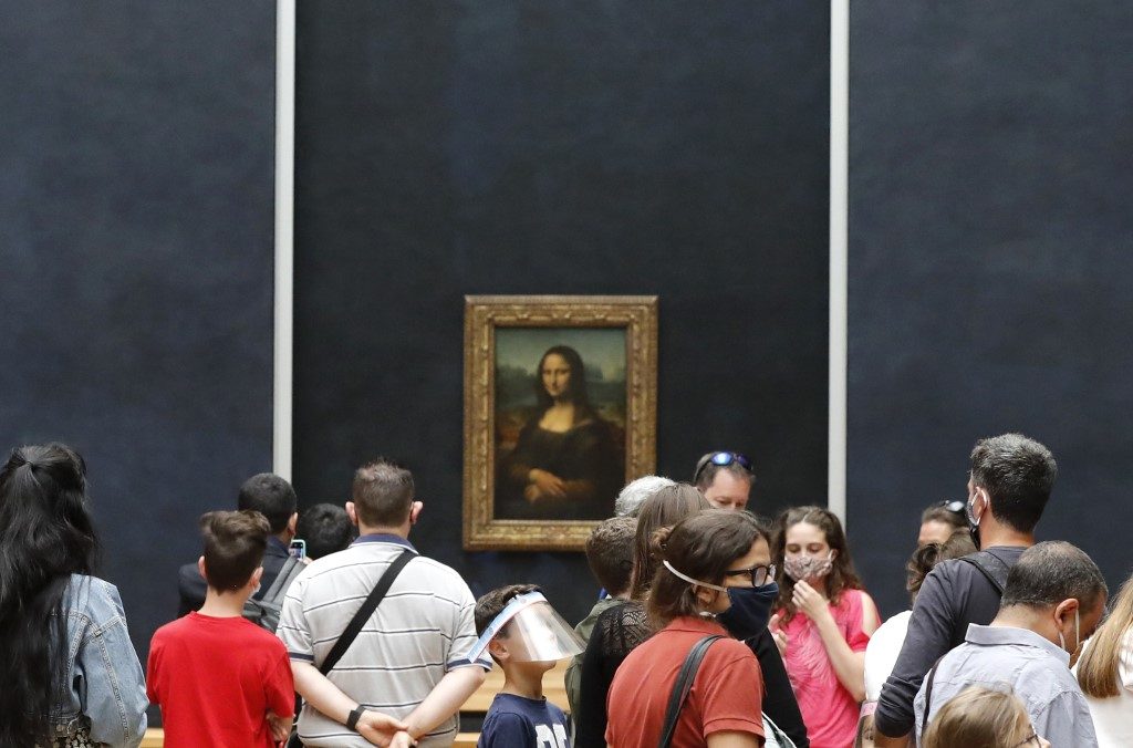 OPEN. Visitors wearing face masks queue in front of Leonardo da Vinci's masterpiece " Mona Lisa " also known as " La Gioconda " held in the Salle des Etats, at the Louvre Museum in Paris on July 6, 2020, on the museum' s reopening day. Photo by Francois Guillot/AFP 