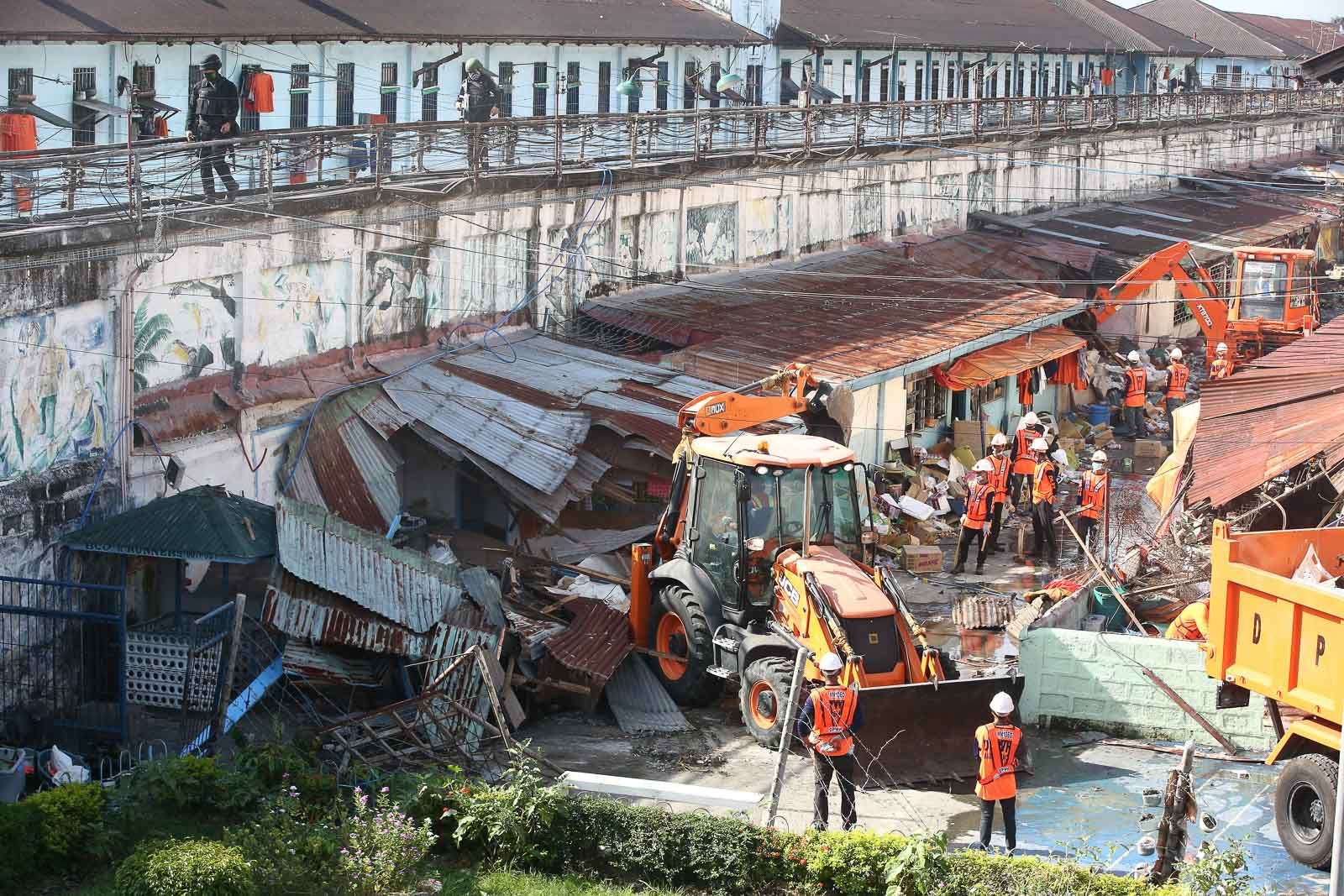DEMOLITION. Workers use heavy equipment as they dismantle illegal structures as ordered by newly installed BuCor chief Gerald Bantag and NCRPO chief Guillermo Eleazar inside the New Bilibid Prison in Muntinlupa City on October 9, 2019. Photo by Ben Nabong/Rappler 