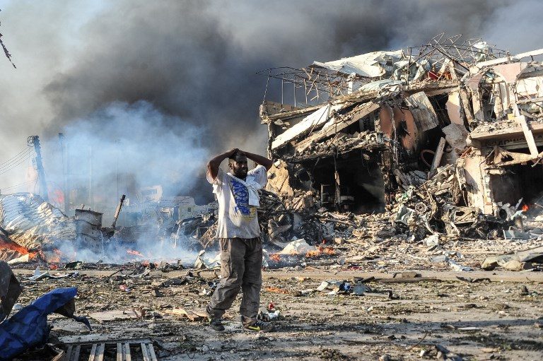 20 KILLED. A Somali man reacts next to a dead body on the site where a car bomb exploded at the center of Mogadishu, on October 14, 2017. Photo by Mohamed Abdiwahab/AFP 