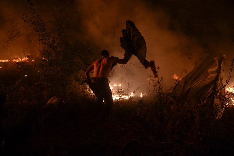WILDFIRE. A man attempts to subdue wildfire flames in Vigo, northwestern Spain, October 15, 2017. Photo by Miguel Riopa/AFP  
