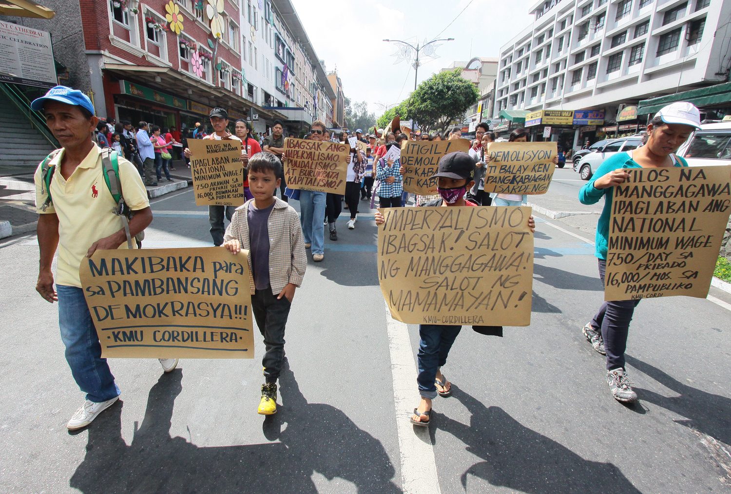 MARCHING. Militants together with their children carry placards in a march rally along the central business district of Session road Baguio City 1 May during the celebration of Labor Day. Photo by Mau Victa/Rappler 