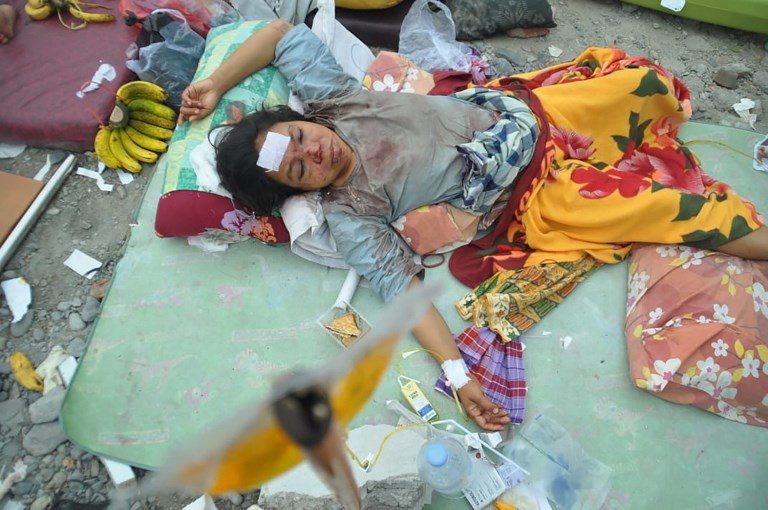 ALIVE, BUT. An injured woman rests at a makeshift hospital in Palu. Photo by Muhammad Rifki/AFP  