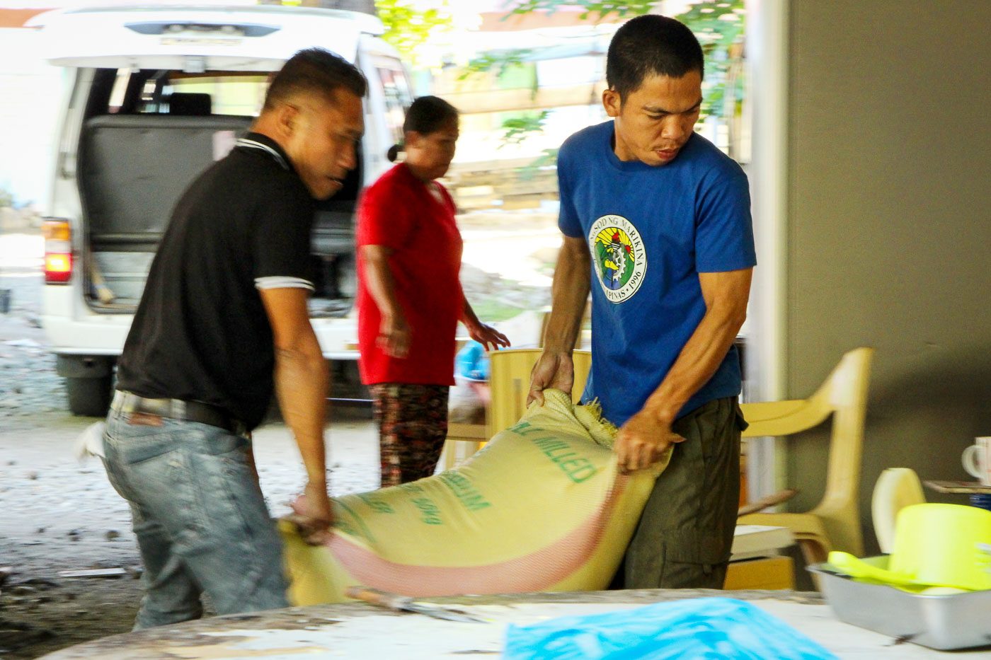 FULL-OUT STRENGTH. Two men assigned in the kitchen volunteer to haul a sack of rice with solid strength and full support to the delegates from Region IX.  
