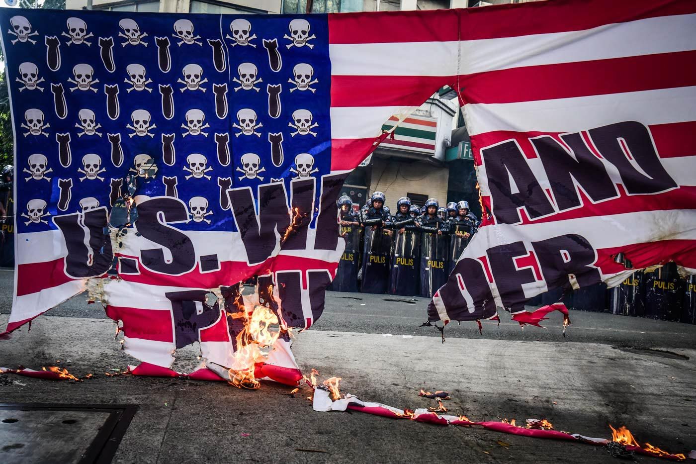 RAGE. The protesters burned down the American flag in front of the police as a sign of protest to Trump's visit to the country. Photo by Alecs Ongcal/Rappler 