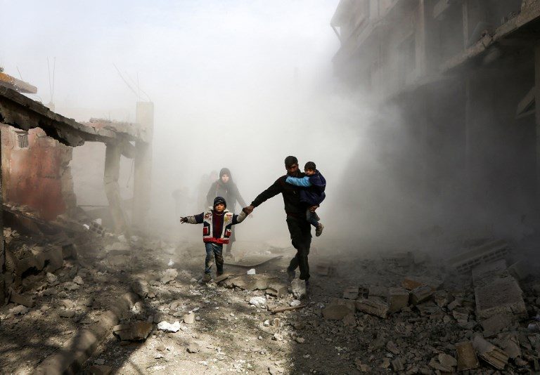 UNDER HEAVY BOMBING RAIDS. Syrian civilians flee from reported regime air strikes in the rebel-held town of Jisreen, in the besieged Eastern Ghouta region on the outskirts of the capital Damascus, on February 8, 2018. Photo by Abdulmonam Essa/AFP  