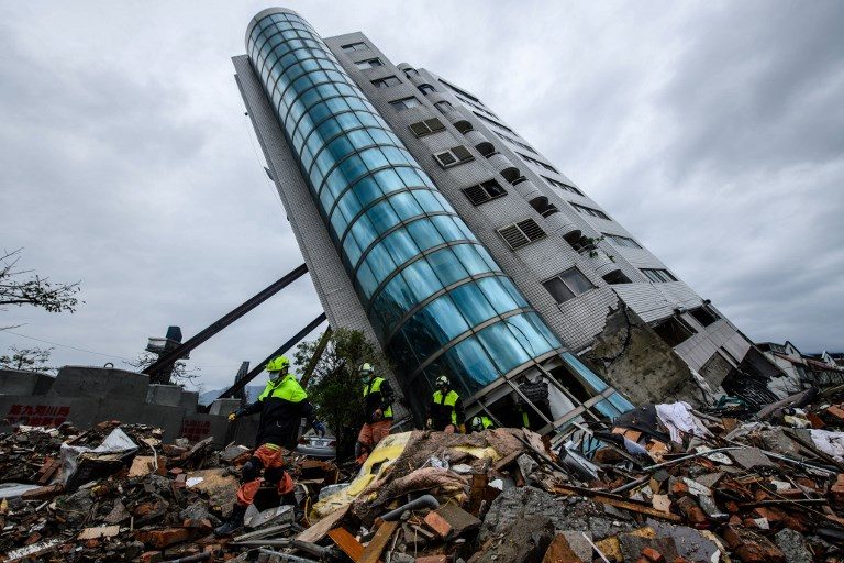 LEANING TOWER. Rescue workers walk out from the Yun Tsui building, which is leaning at a precarious angle, in the Taiwanese city of Hualien on February 8, 2018 after the city was hit by a 6.4-magnitude quake late on February 6. Photo by Anthony Wallace/AFP  