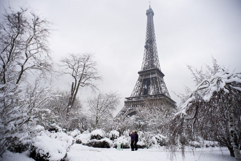 PARISIAN WINTER. People walk through the snow covered Champ de Mars garden near the Eiffel tower on February 7, 2018 following heavy snowfall in Paris. Photo by Alain Jocard/AFP  