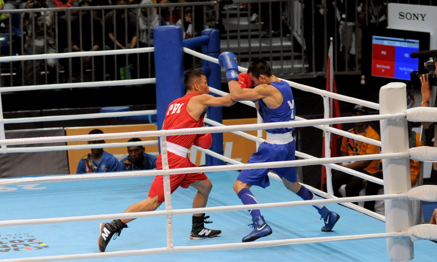 ON TO THE SEMIS. Mario Fernandez of the Philippines lands a right hand through the gloves of Vietnam's Tran Phu Cuong to advance to the semis. Photo by Adrian Portugal/Rappler   