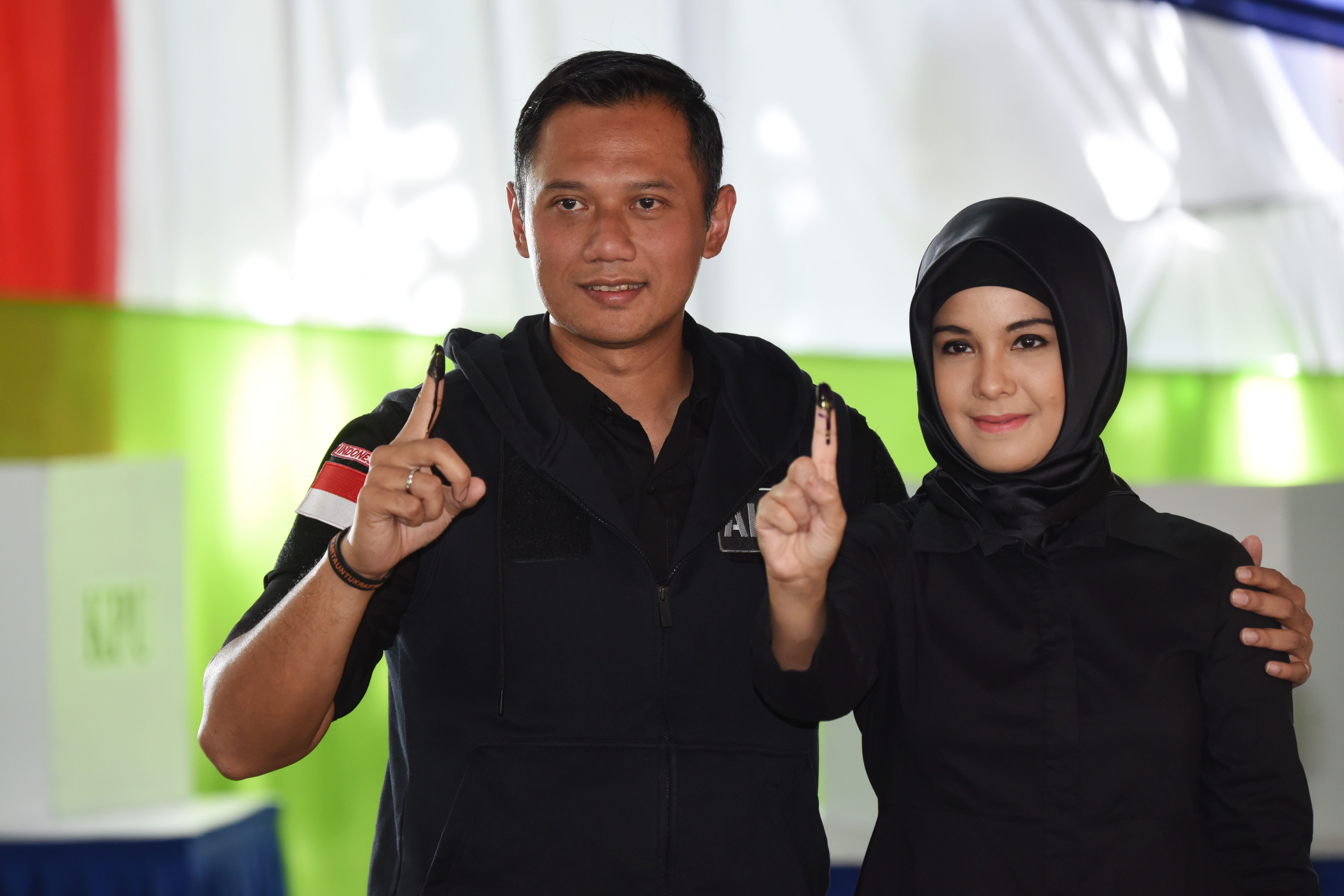 Cagub Agus Harimurti Yudhoyono (kiri) bersama istri, Annisa Pohan (kanan), menunjukkan jari yang telah dicelup tinta usai mengikuti proses pencoblosan Pilkada DKI Jakarta di TPS 6, Rawa Barat, pada 15 Februari 2017. Foto oleh Akbar Nugroho Gumay/Antara 