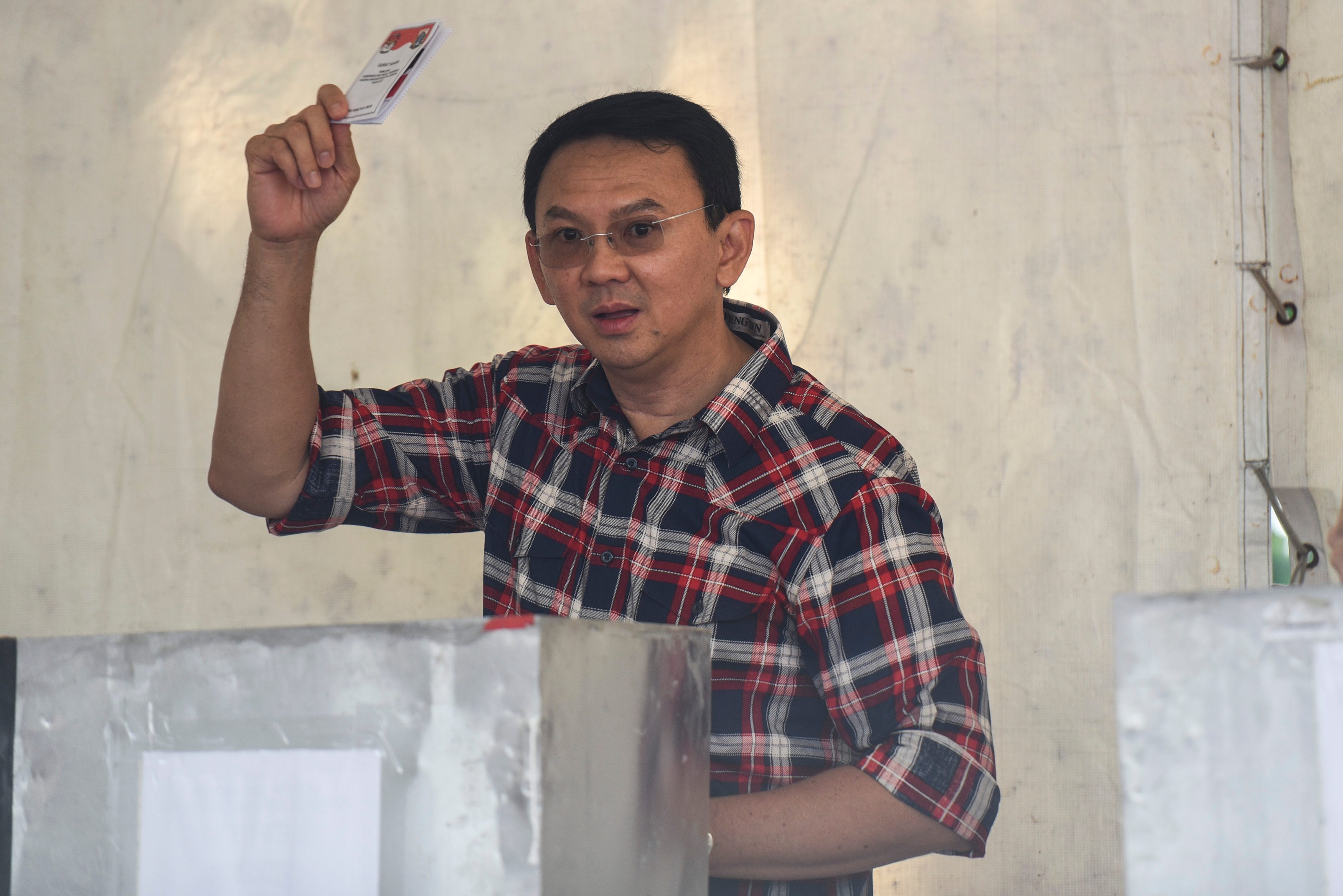 Cagub DKI Jakarta nomor urut dua, Ahok, menunjukkan surat suara saat melakukan pencoblosan di TPS 54 kawasan Pantai Mutiara, Pluit, pada 15 Februari 2017. Foto oleh Hafidz Mubarak A./Antara 