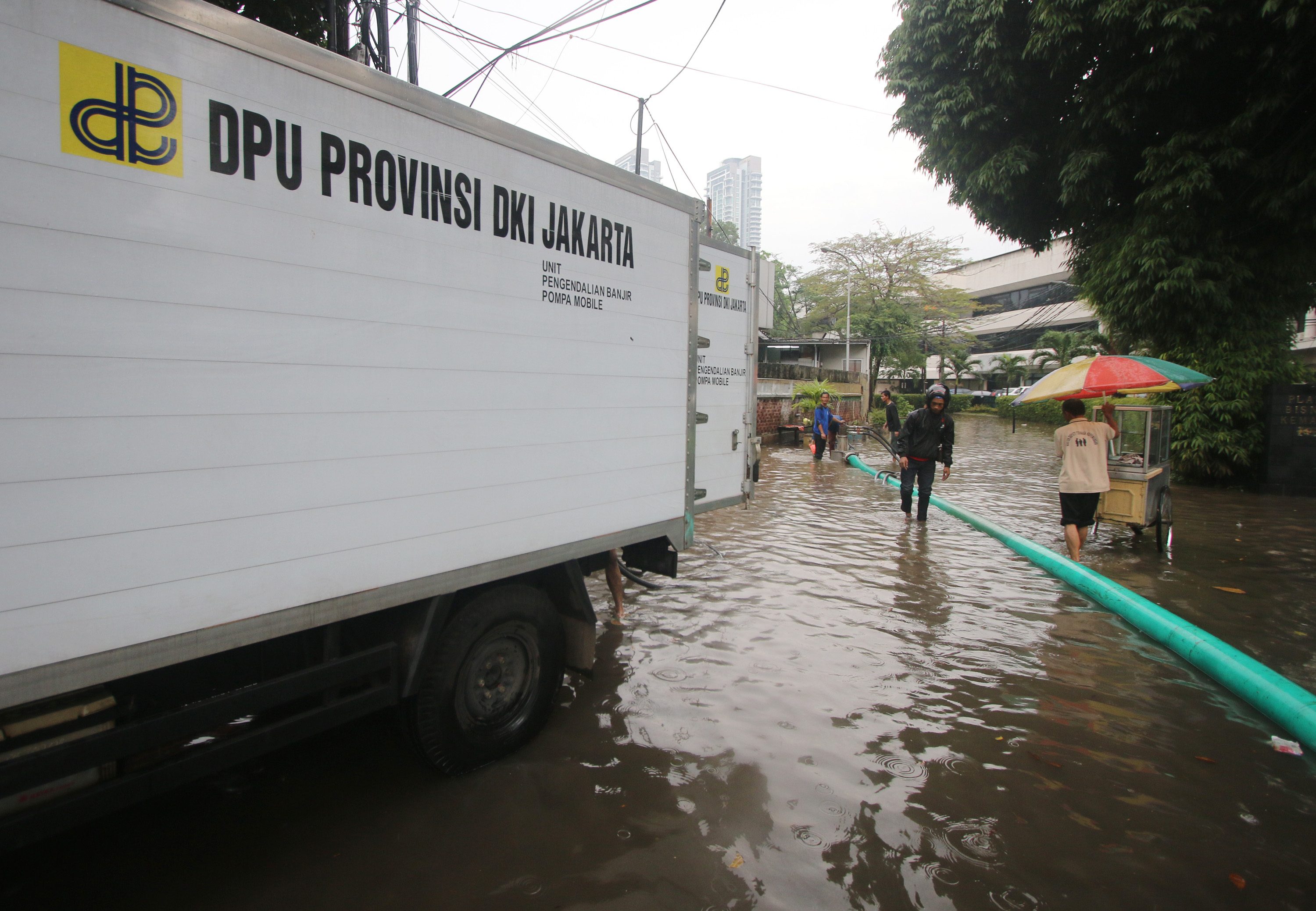 Petugas Dinas Tata Air melakukan penyedotan air dengan mesin pompa saat banjir menggenangi kawasan Kemang, Jakarta Selatan, pada 4 Oktober 2016. Foto oleh Reno Esnir/Antara 