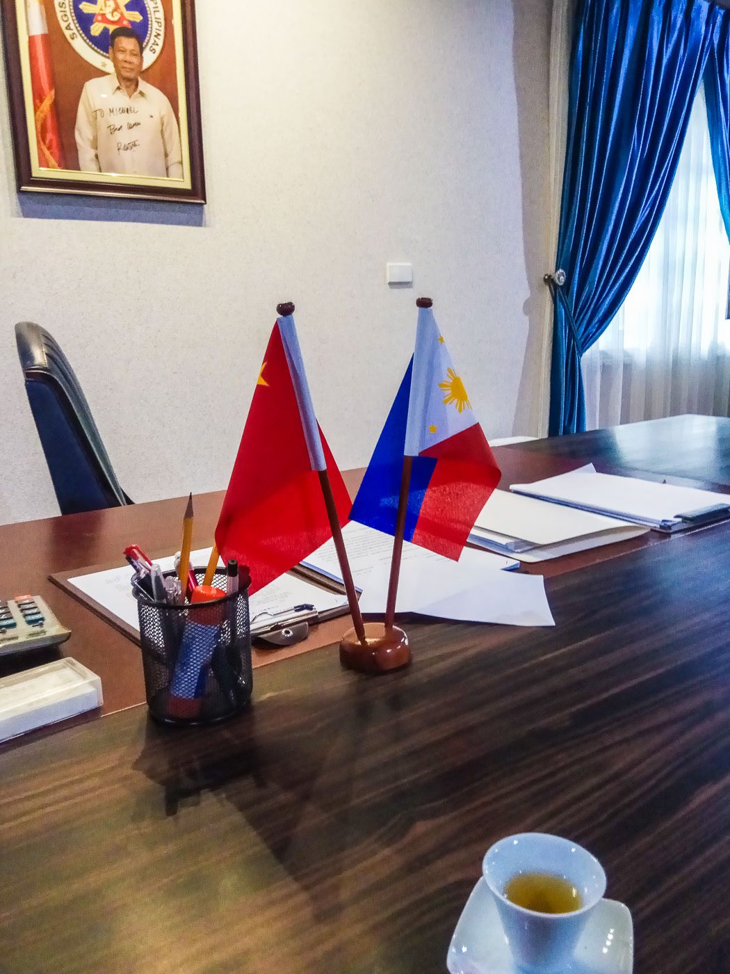 CLOSE TIES. A desk in Michael Yang's office stands in front of a signed portrait of President Rodrigo Duterte. Sourced photo 