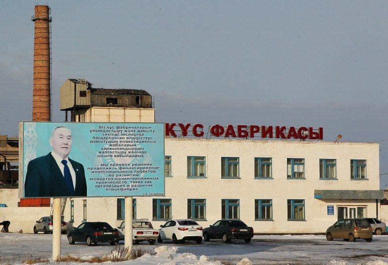 A picture taken on December 14, 2016 shows a factory and a billboard bearing the portrait of Kazakhstan's President Nursultan Nazarbayev, in the town of Arkalyk, central Kazakhstan. Stanislav Filippov/AFP 