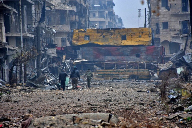 GHOST TOWN. Syrian pro-government forces walk in Aleppo's Bustan al-Qasr neighborhood after they captured the area in the eastern part of the war torn city on December 13, 2016. George Ourfalian/AFP 