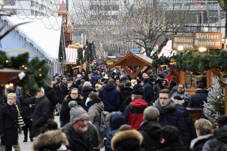 OPEN AGAIN. People walk between booths at the Christmas market near the Kaiser-Wilhelm-Gedaechtniskirche (Kaiser Wilhelm Memorial Church) in Berlin on December 22, 2016. Tobias Schwarz/AFP 
