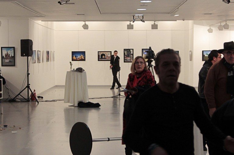 CHAOS. This picture taken on December 19, 2016 in Ankara shows guests leaving a gallery as a gunman (C) holds a weapon, during an attack where Andrey Karlov, the Russian ambassador to Ankara, has been shot. Hasim Kilic/Hurriyet/AFP 