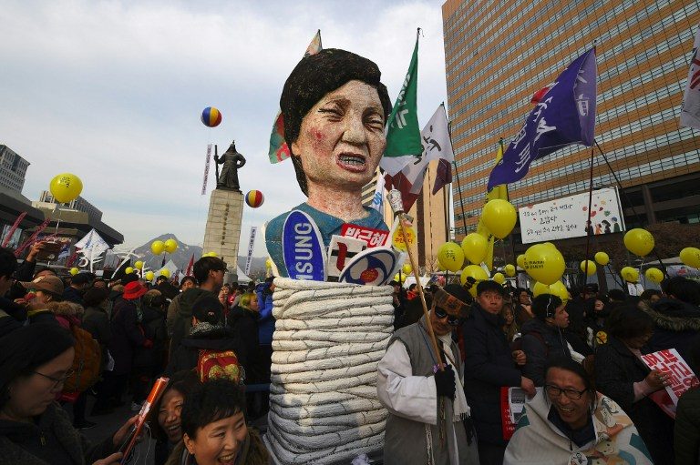 Protesters carry an effigy of South Korea's President Park Geun-Hye during a rally against Park in central Seoul on December 3, 2016. Jung Yeon-Je 