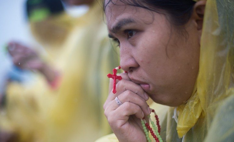 WEEPING SURVIVORS. A devotee prays during a mass held by Pope Francis in Tacloban on January 17, 2015. Pope Francis on January 17 celebrated an emotional mass with a sea of weeping survivors of a super typhoon in the Philippines that claimed thousands of lives, saying their pain had silenced his heart. Photo by Johannes  PHOTO / JOHANNES EISELE 