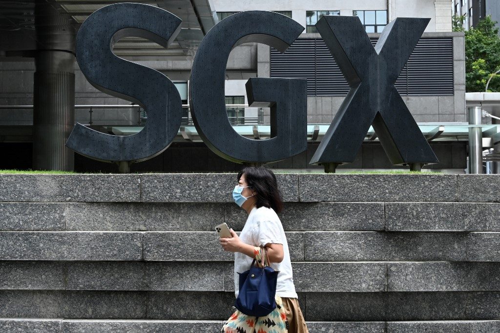 SAFETY MEASURES. A woman, wearing a face mask as a preventive measure against the spread of COVID-19, walks past the Singapore Exchange (SGX) stock exchange building on April 7, 2020. Photo by Roslan Rahman/AFP  