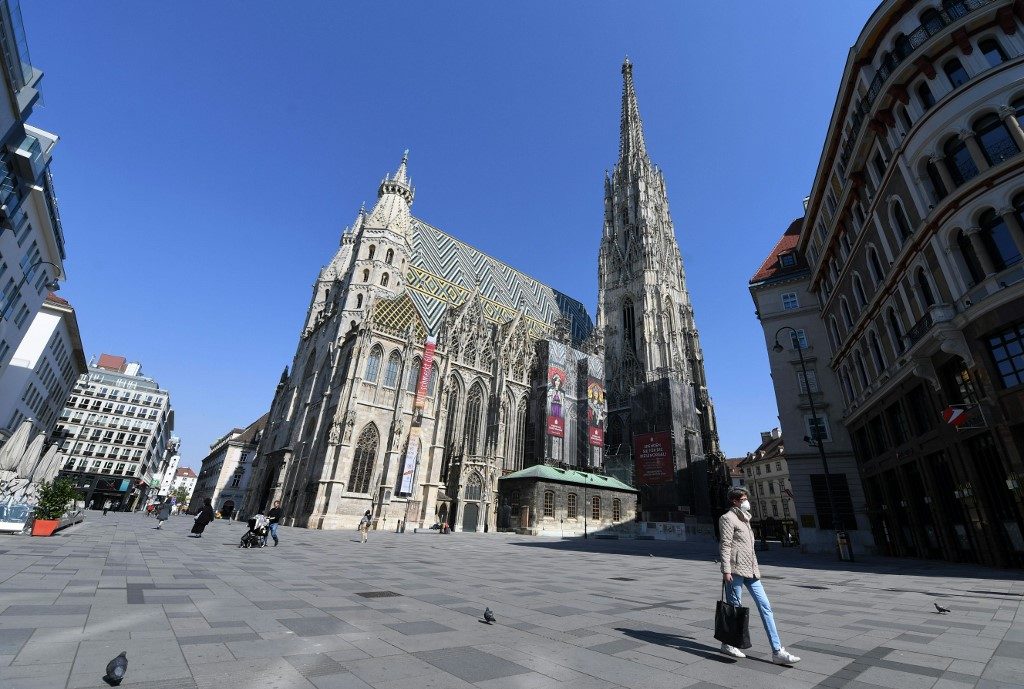 ISOLATED. A woman with face protection mask walks past Saint Stephen's Cathedral (Stephansdom) in Vienna on April 6, 2020 during the exit restrictions amid the COVID-19 pandemic. Photo by HELMUT FOHRINGER / APA / AFP / Austria OUT 
