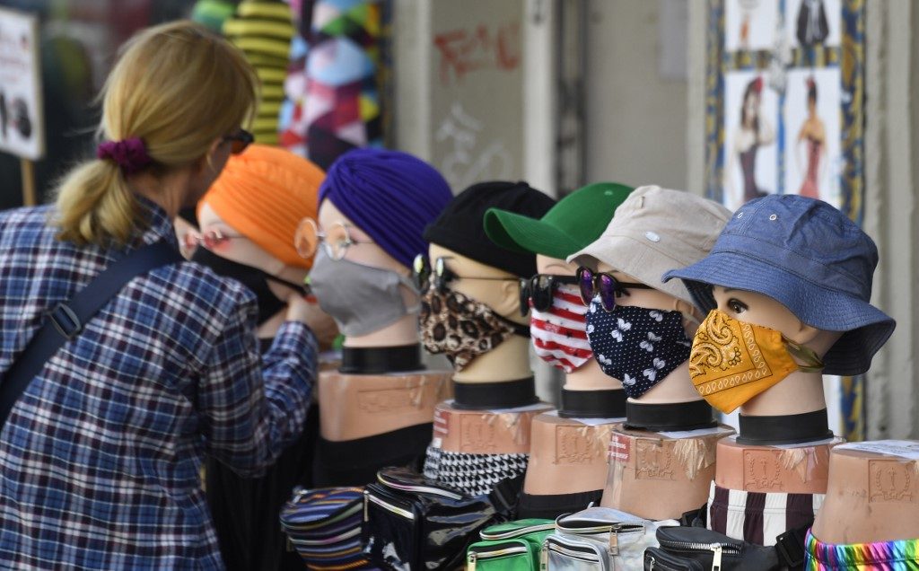 MASKS. A woman checks out face covers on display outside a clothing store in Berlin, Germany, on April 28, 2020. Photo by John MacDougall/AFP 