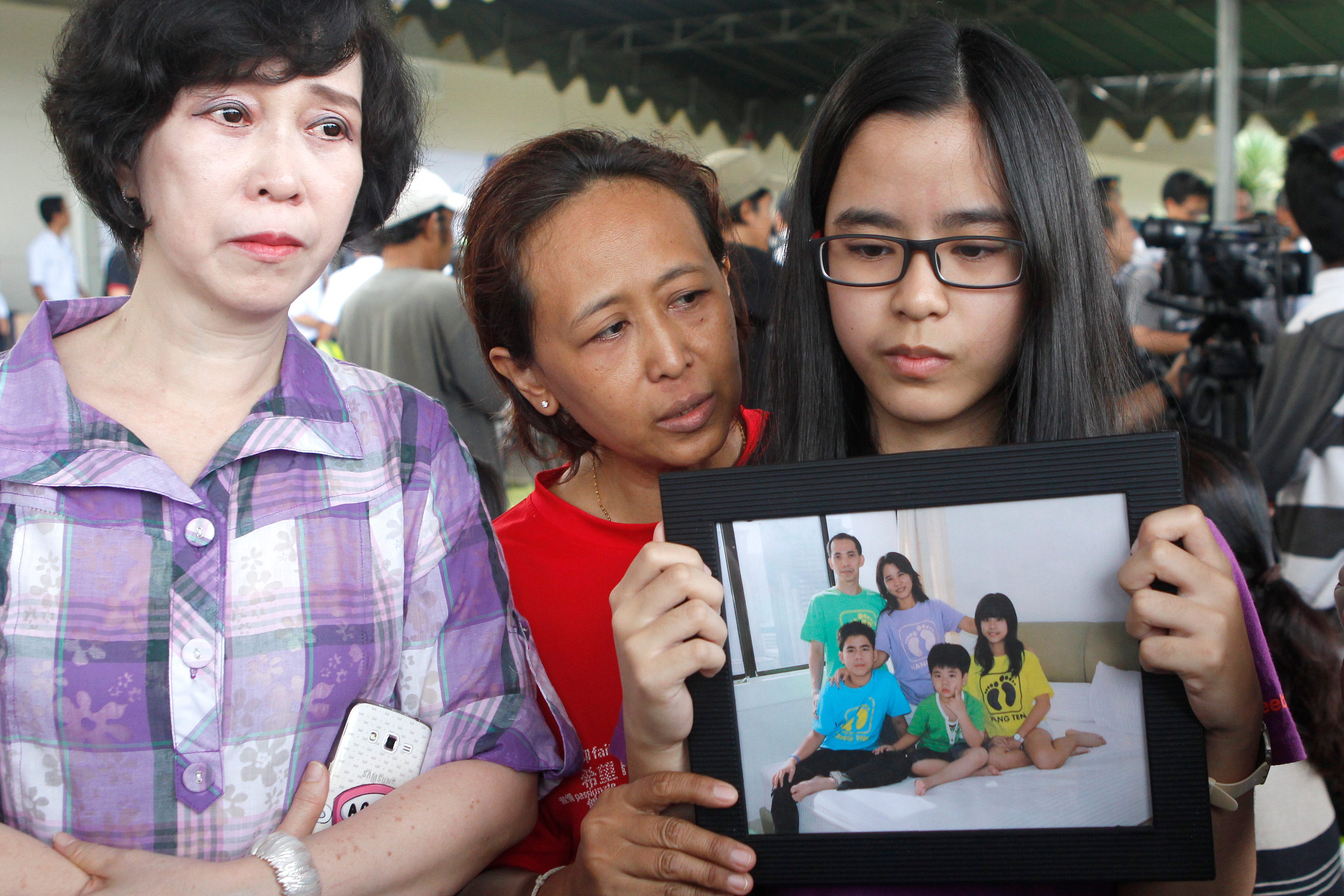 Relatives hold a picture of the Herumanto Tanus family as they wait for news at Juanda Airport on December 29, 2014.  Photo from EPA