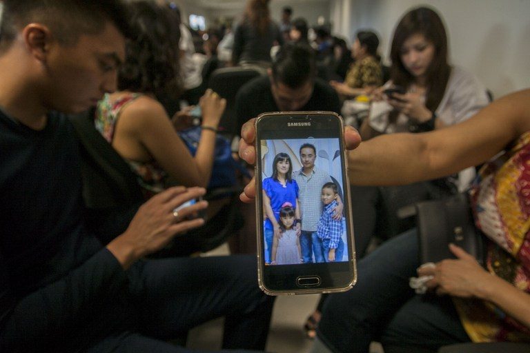 A relative waiting for news in Surabaya shows a picture of passengers on the flight on December 28, 2014.  Photo by AFP