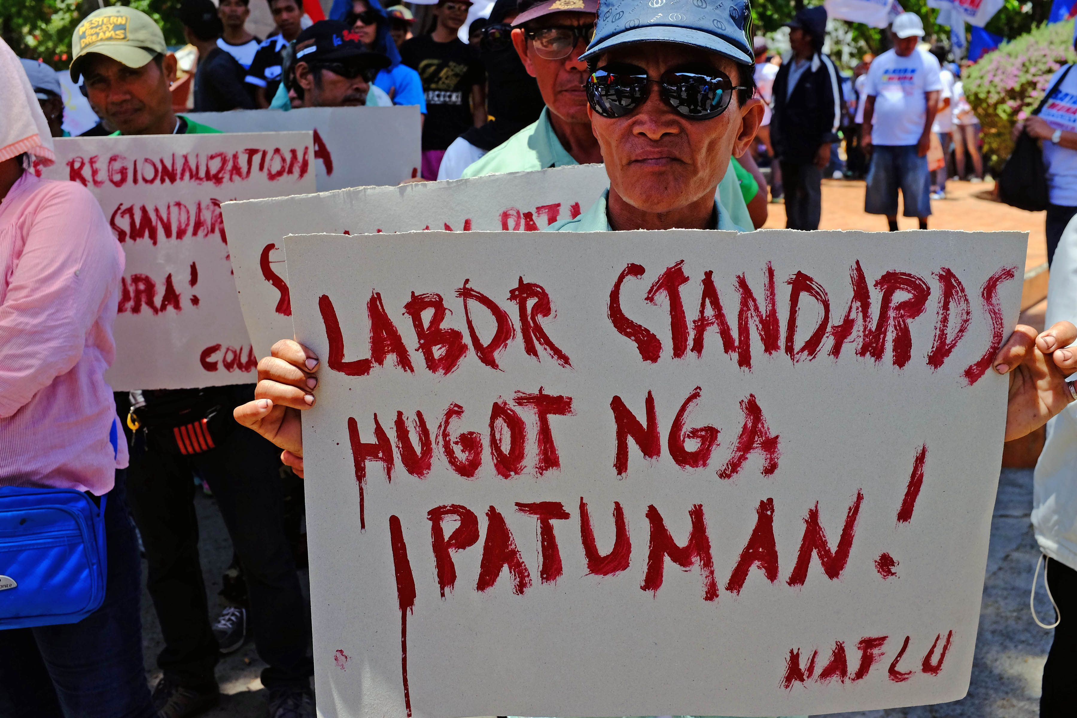 LABOR RIGHTS. A laborer and union member from the Bagong Buhay Arastre and Stevedoring, Inc. calls demands for the govenrment to strictly implement fair labor practices. Photo by Bobby Lagsa/Rappler 