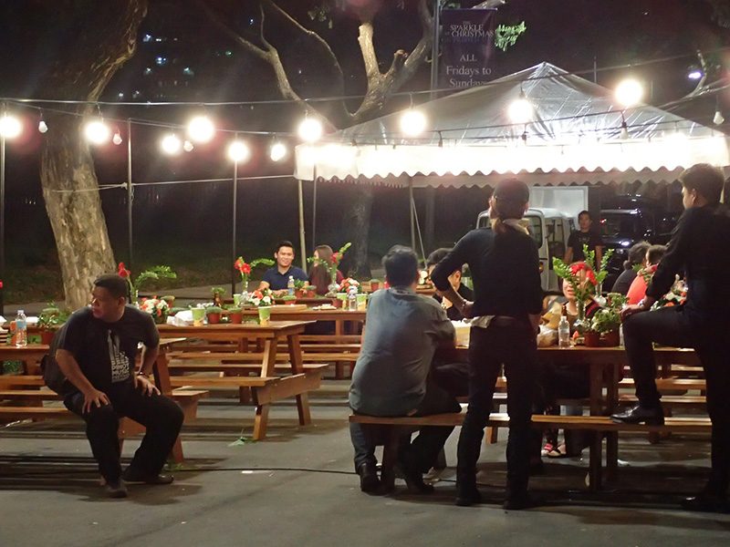 FOR SNACKS OR DINNER. Near the market booths are tables where people can sit, eat, or simply rest for a bit. 
