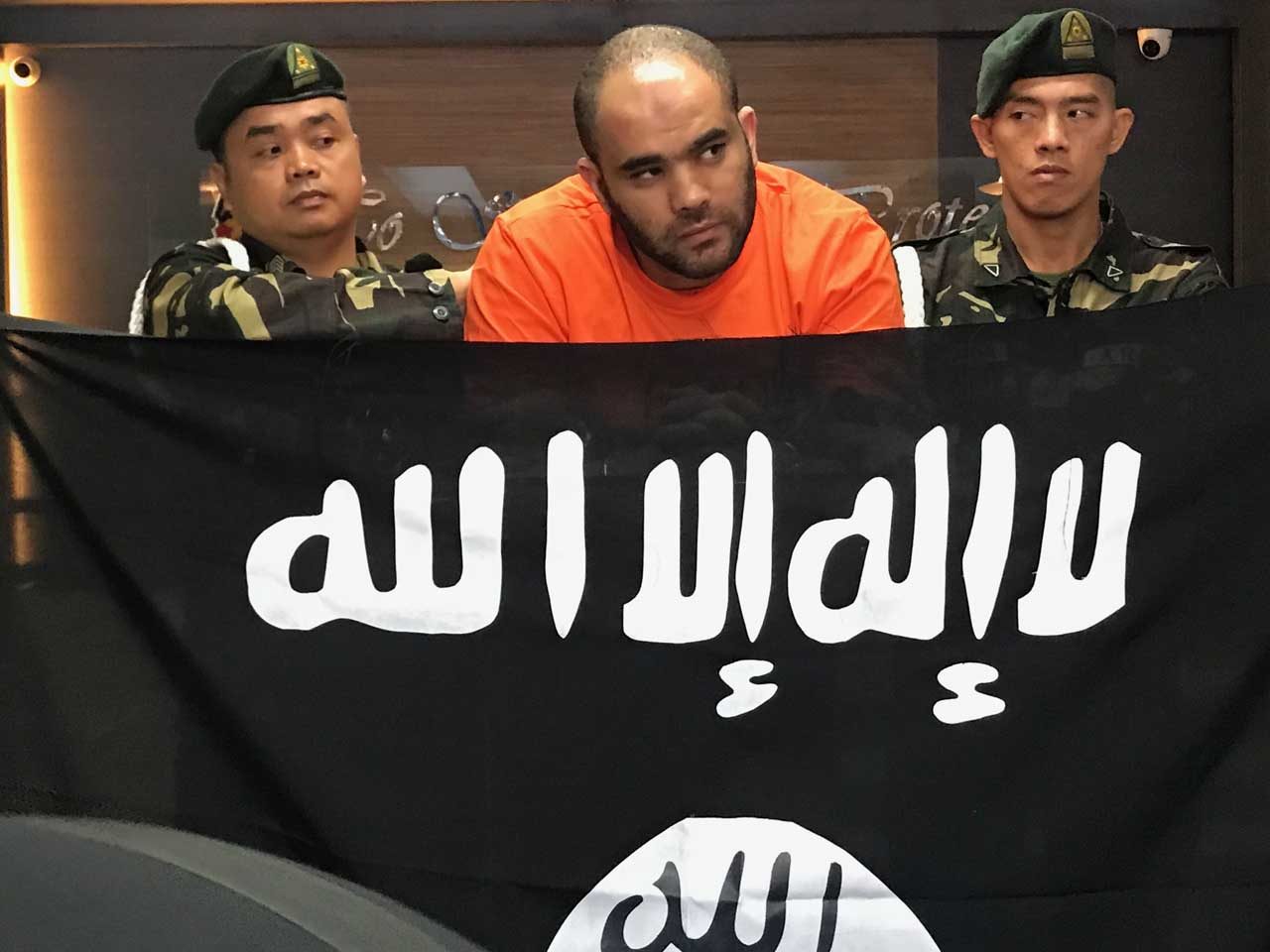 PRESENTATION. Suspect Fehmi Lassqued is presented in Camp Crame, Quezon City complete with an Islamic State (ISIS) flag allegedly found in his possession. File photo by Rambo Talabong/Rappler 