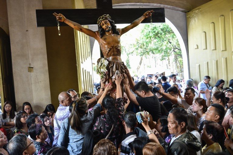 ASH WEDNESDAY. Catholic devotees touch a crucifix as they pray at the National Shrine of the Mother of Perpetual Help in Parañaque on March 6, 2019. Photo by Ted Aljibe/AFP  