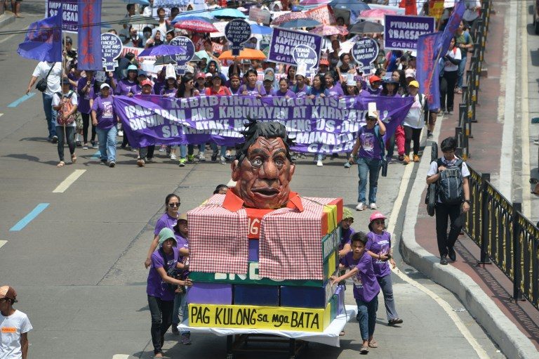 WOMEN'S MARCH. Activists from Gabriela push a carriage with an effigy of President Rodrigo Duterte as they march to Malacanang Palace to commemorate International Women's Day on March 8, 2019. Photo by Ted Aljibe/AFP   
