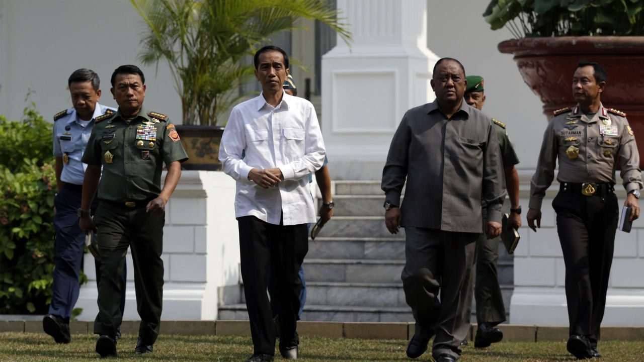 President Joko Widodo (C) is accompanied by military, intelligence and national police leaders as he arrives for a press conference at the presidential palace in Jakarta on October 22, 2014.  Photo by Mast Irham/EPA