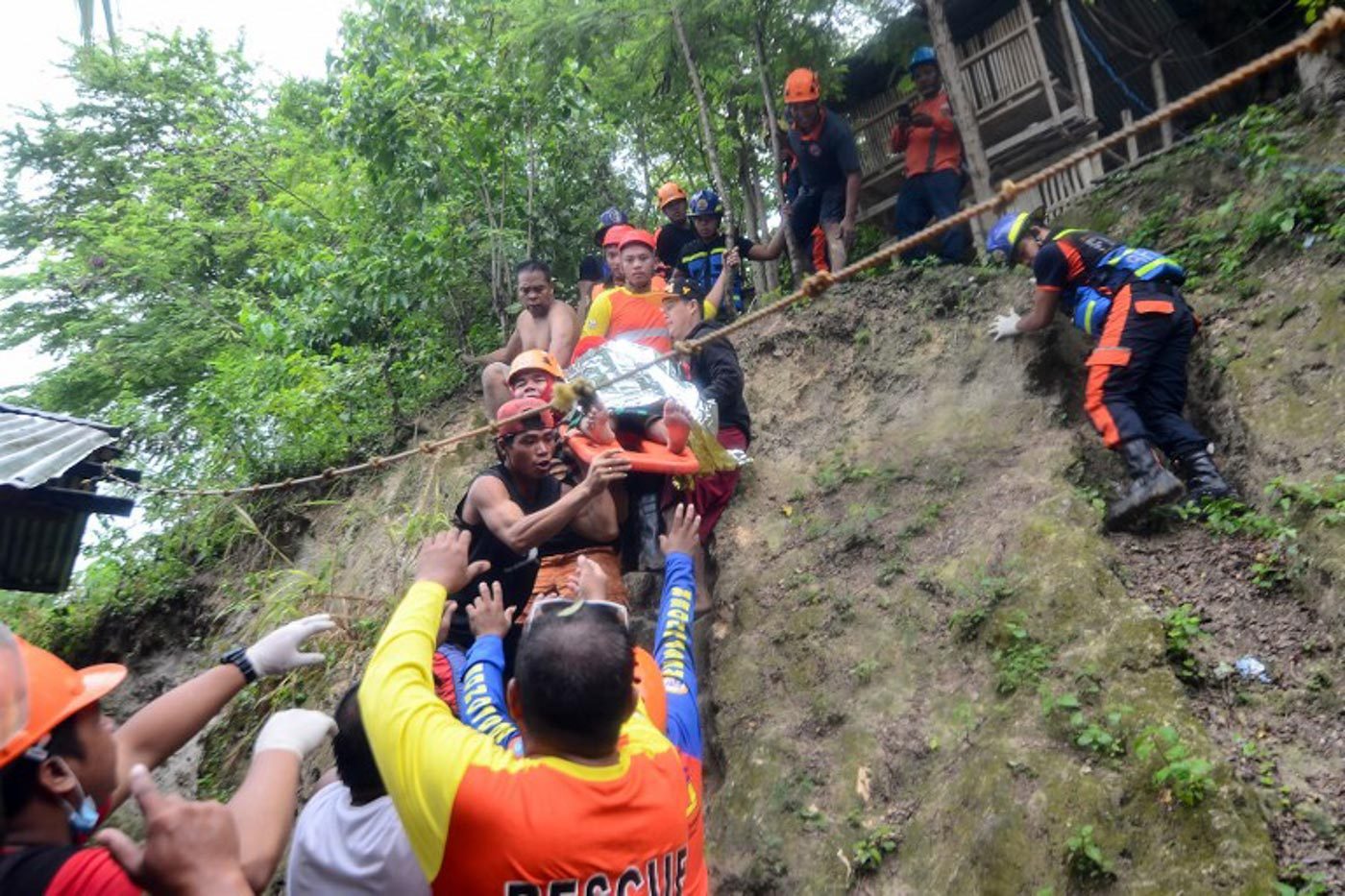 RESPONDERS. Rescuers carry a resident rescued from the landslide site in Naga City, on the popular tourist island of Cebu on September 20, 2018. Photo by Alan Tangcawan/AFP 