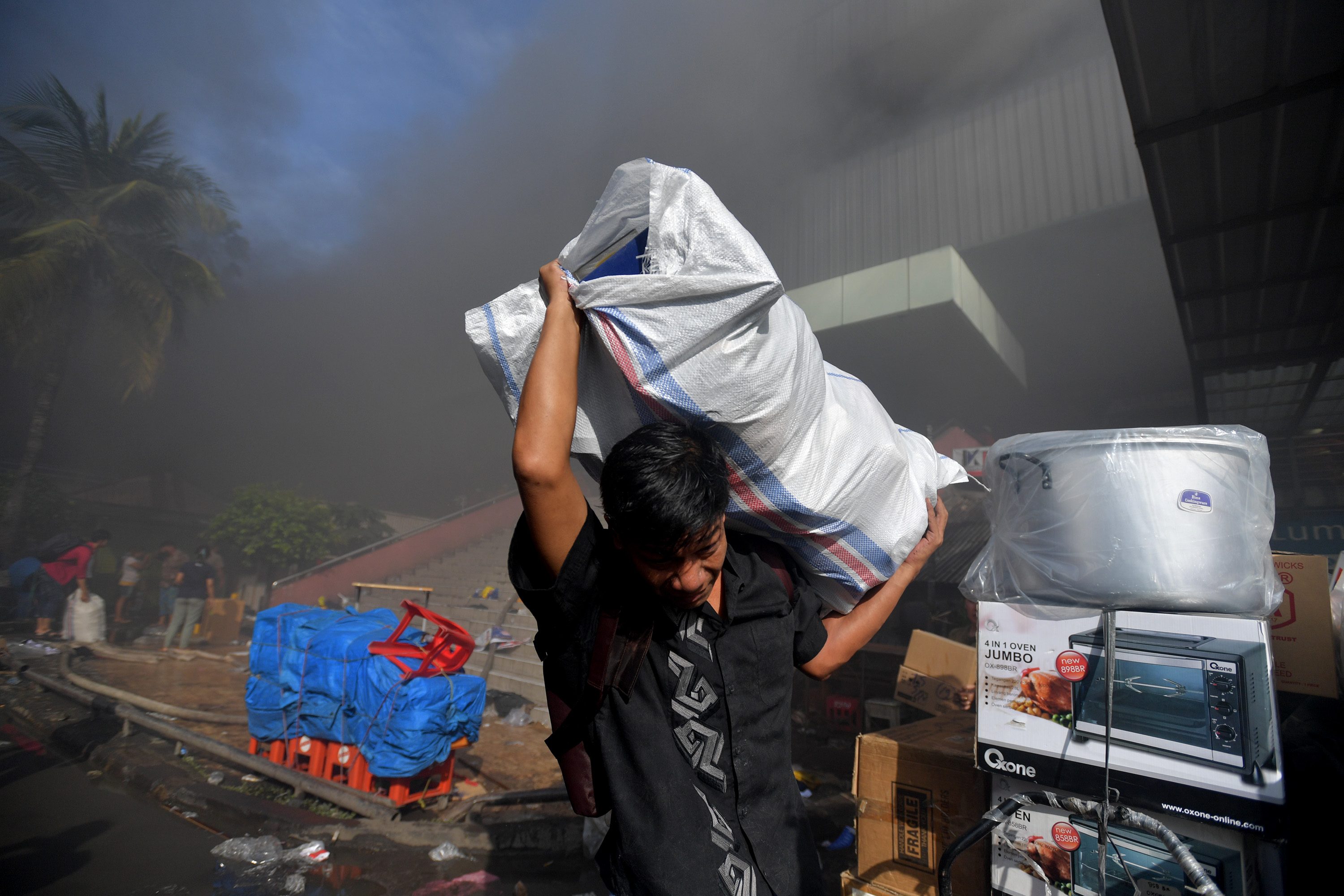 Seorang pedagang menyelamatkan barang-barangnya dari lokasi Blok I dan Blok II Pasar Senen yang terbakar. Foto oleh Widodo S. Jusuf/Antara 