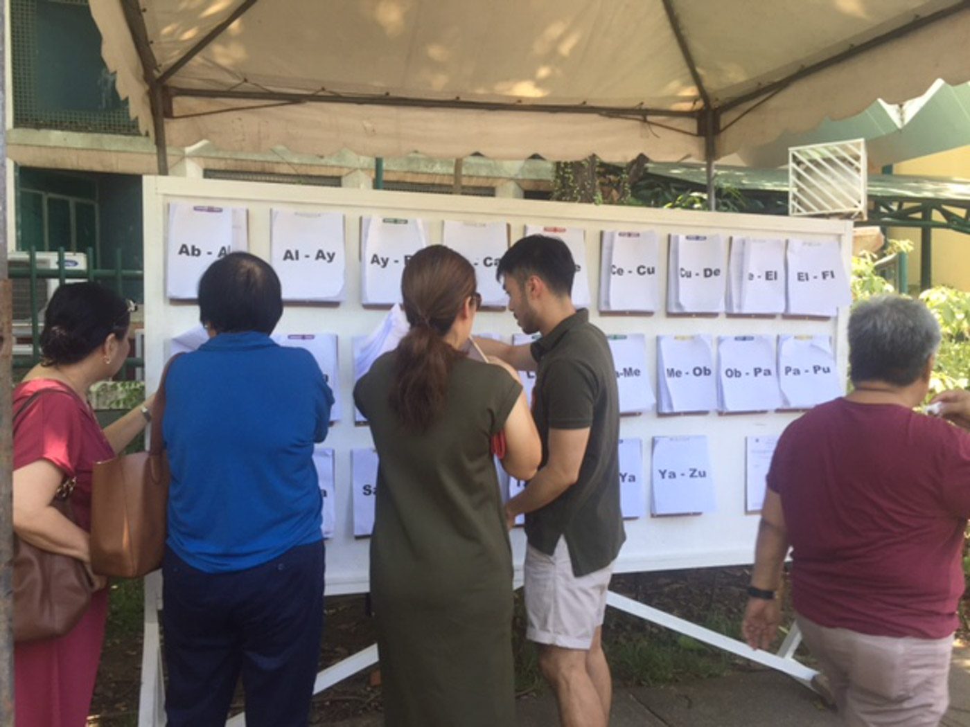 CHECKING PRECINCTS. Voters look for their assigned precincts in Barangay Ayala Alabang. Photo by Sofia Tomacruz/Rappler 