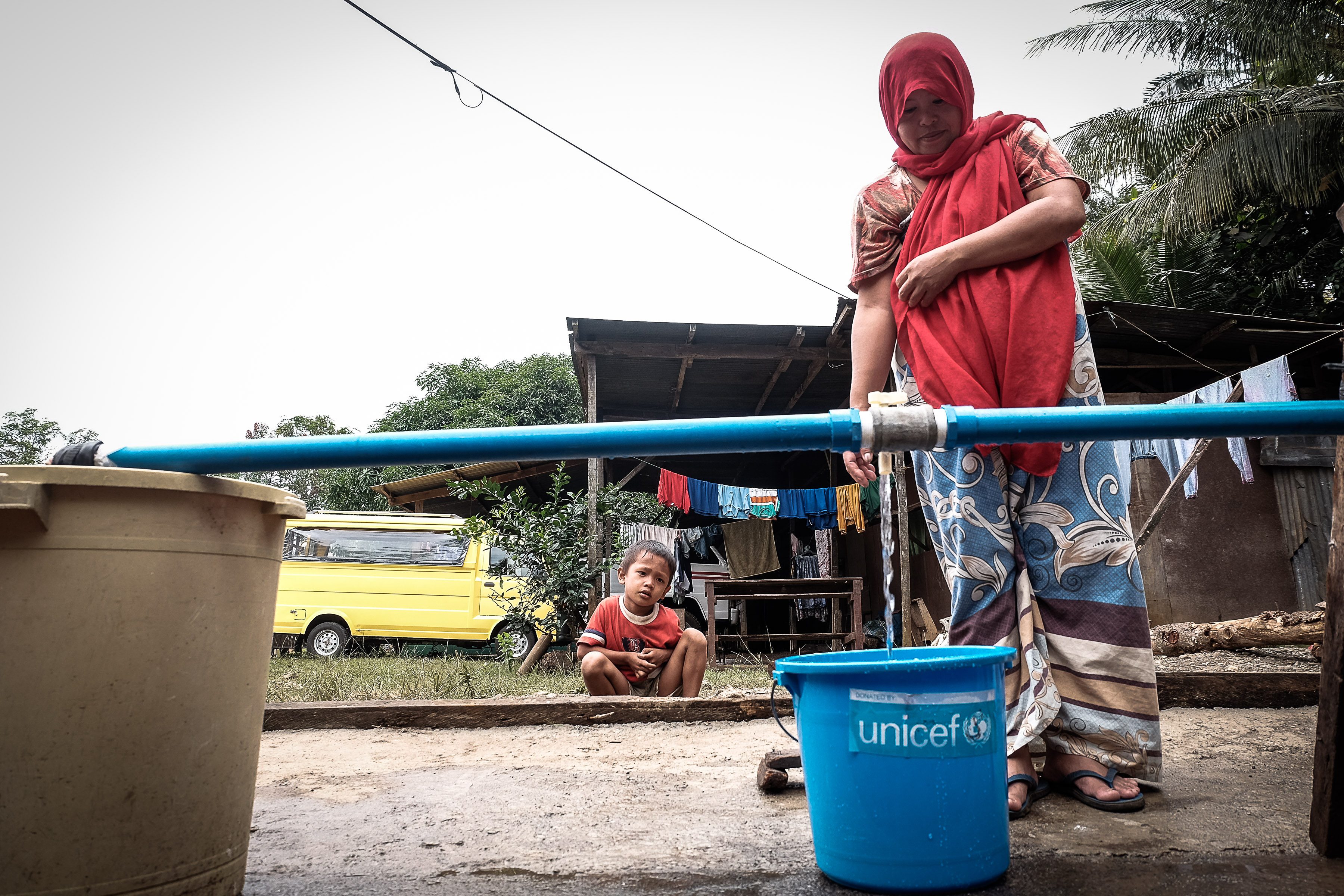 A Maranao woman fetches water for her use in a comfort room inside an evacuation center in Balo-i, Lanao del Norte.  